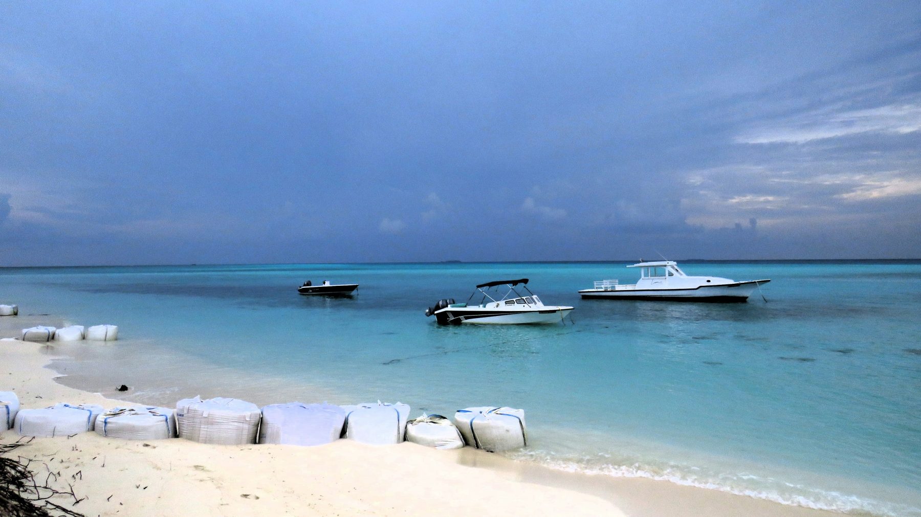 Small boats moored in the turquoise lagoon off Fulidhoo Island, Vaavu Atoll, Maldives