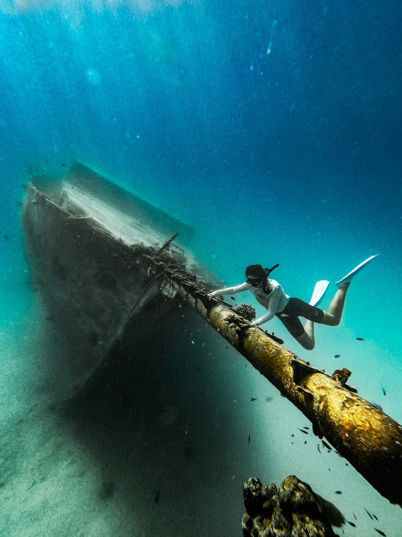 Free-diver exploring the shallow shipwreck near Mathiveri Island, North Ari Atoll, Maldives
